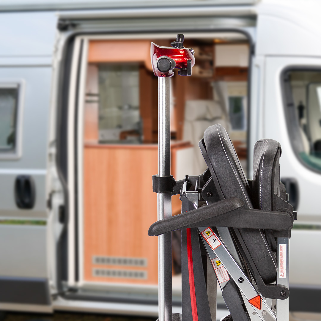 Faltbares Mini-Reise-Elektromobil steht vor einem Campingwagen